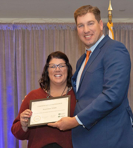 The Stanislaus Young Farmers & Ranchers Committee, represented by Miranda Blagg, left, receives the YF&R award for the most innovative event from Daniel Jones, YF&R State Committee chair.