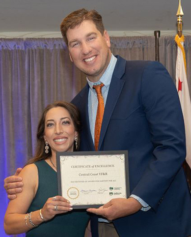 The Central Coast Young Farmers & Ranchers Committee, represented by Jynel Gularte, left, receives the YF&R award for Harvest for All projects from Daniel Jones, YF&R State Committee chair.