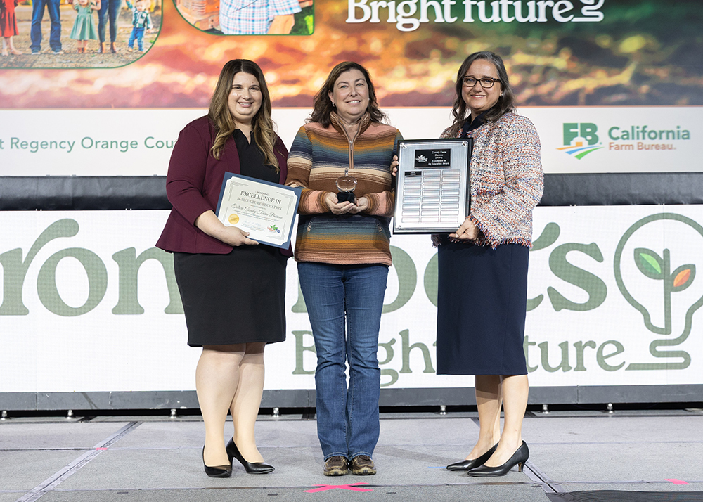 Tricia Stever Blattler, center, accepts the Excellence in Ag Education Award on behalf of the Tulare County Farm Bureau from Amanda Fletcher, executive director of California Foundation for Agriculture in the Classroom, left, and Shannon Douglass, president of the California Farm Bureau.