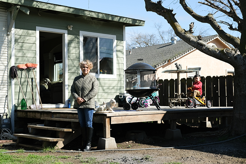 Leticia Hermosillo, una jefa de cuadrilla de granjas en el condado de Colusa, fotografiada con el hijo de un compañero de trabajo el mes pasado en su casa en Williams.
