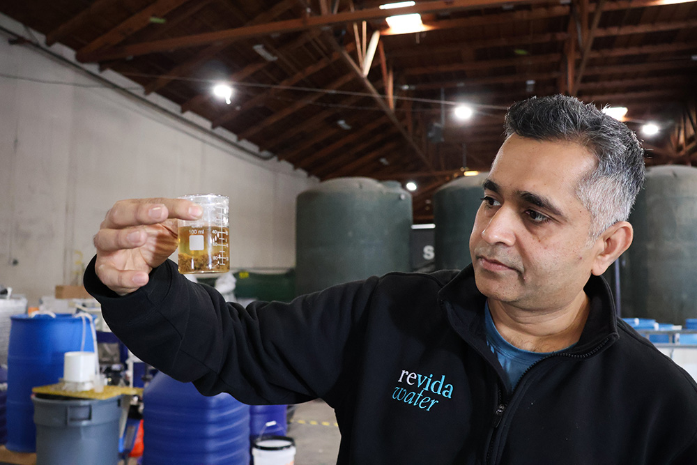 Revida Water founder Ashish Shah holds a cup of wastewater that’s midway through treatment. His company can take wastewater from dairies and wineries and convert it into drinkable water. 