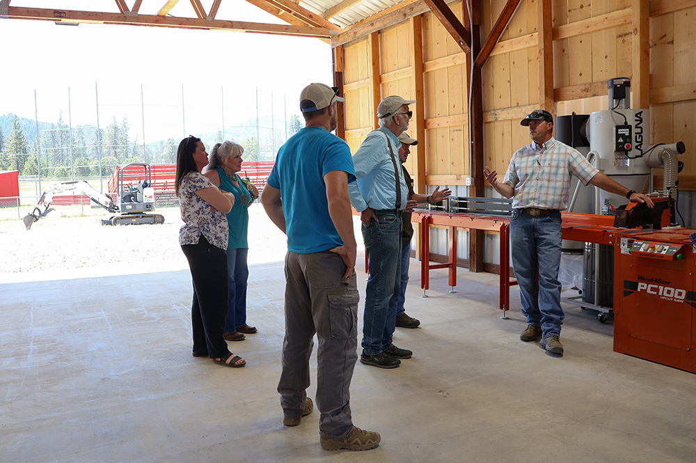 Hayfork High School Agricultural Teacher Morgan Rourke (right) showcases the school’s sawmill operation to visitors at its grand opening on May 20, 2026.